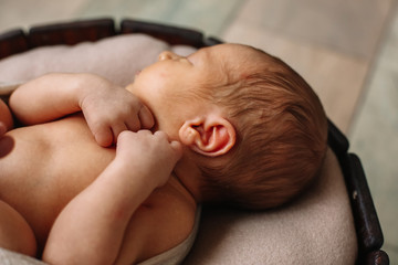 
Newborn baby boy, in the photo the baby is 7 days old from birth, wrapped in a wrapping, sleeps sweetly in a basket