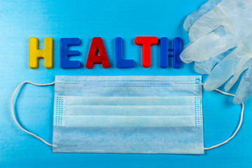The word health consists of letters. Protection from coronavirus, medical mask and gloves.Means of protection in a public place.