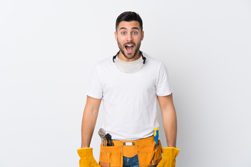 Craftsmen or electrician man over isolated white background with surprise facial expression