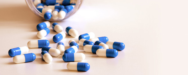 Image with pharmacy drugs for banner design. Medical capsules are lying on the table close-up.
