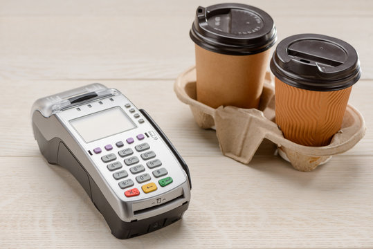 Two coffee cups and credit card reader