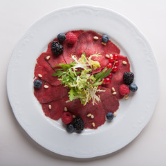 Carpaccio with salad and currants.
