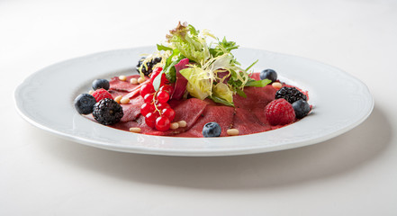 Carpaccio with salad and currants.