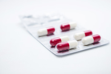 White and red pills on a white background. Isolated. Side view.