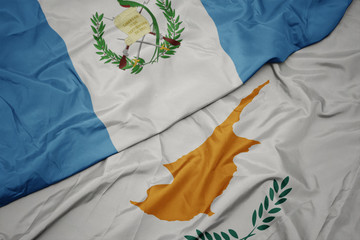 waving colorful flag of cyprus and national flag of guatemala.