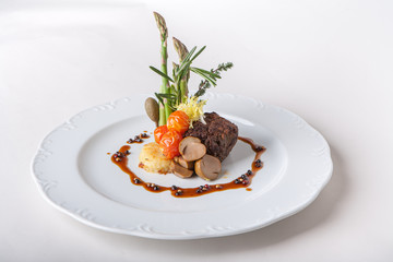 Steak with mashed potatoes and asparagus. Mushrooms, tomatoes, sauce, capers.