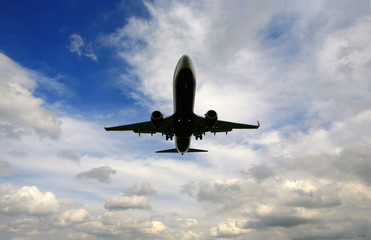 lądujący samolot pasażerski na tle pochmurnego nieba 