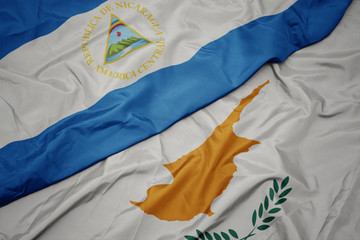 waving colorful flag of cyprus and national flag of nicaragua.