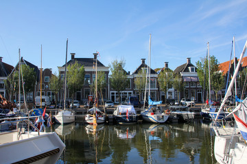 Fototapeta na wymiar Harlingen Harbor with boats and their reflections on the water