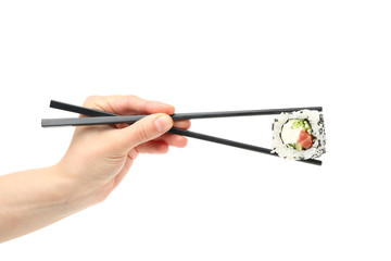 Female hand with chopsticks holds sushi roll, isolated on white background