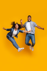 Happy African Couple Fooling Together, Jumping High On Air In Studio