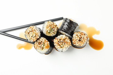 Delicious sushi rolls, soy and chopsticks on white background, top view