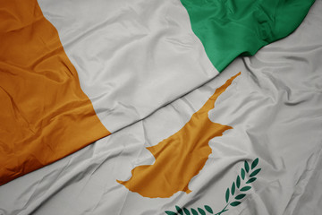 waving colorful flag of cyprus and national flag of cote divoire.