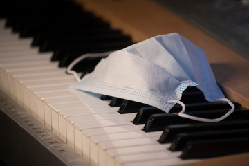 White safety breathing mask on piano top view. Medicine anti-virus mask with filter