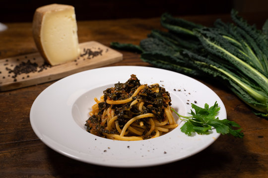 Pici Senesi of fresh pasta with black cabbage sauce with parsley garnish on the table of an old tavern