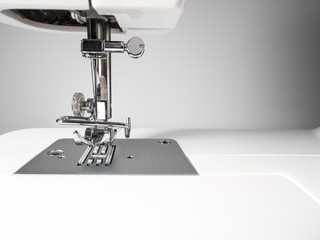 Sewing machine detail on a white wall background