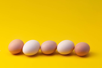 natural homemade chicken eggs on a yellow background