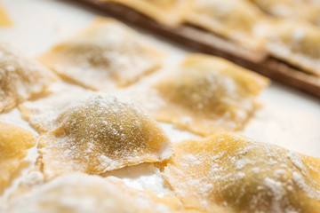 Fresh homemade italian pasta ravioli with ricotta and spinach. The process of cooking. Selective focus.