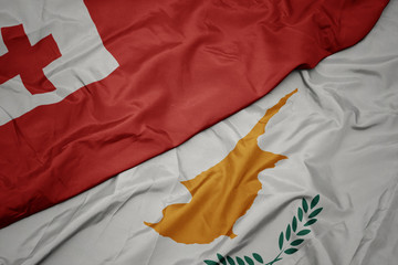 waving colorful flag of cyprus and national flag of Tonga .