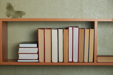 Education learning concept with opening book or textbook in old library, stack piles of literature text academic archive on reading desk and aisle of bookshelves in school study class room background