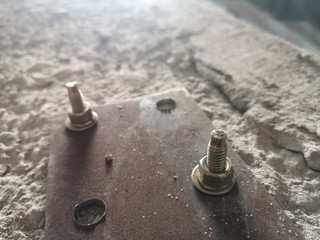 Sheet metal bracket on the concrete surface. A sheet metal screws with cement