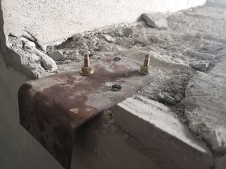 Sheet metal bracket on the concrete surface. A sheet metal screws with cement