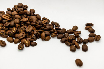 Whole coffee beans on a white background. Selective focus