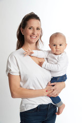 A mother holds her infant son on a white backdrop