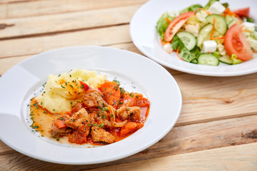 chicken with mashed potatoes and salad on the wooden background