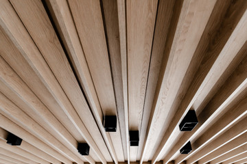 creative ceiling with wood paneling,modern wooden suspended ceiling,black loft lights in the ceiling,energy saving light bulbs