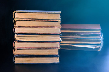 A stack of old books on a dark background. Close-up.