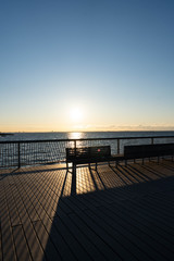 Fototapeta na wymiar Sunrise over Atlantic Ocean, blue sky, piers. Pier and blue Atlantic Ocean. Red sky sun beams. 