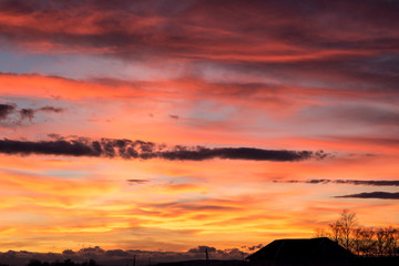 Sunset. Evening sky, clouds are painted in different bright colors: blue, red, orange, purple, pink, yellow.