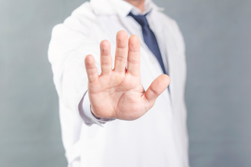 doctor shows his hand to stop the virus