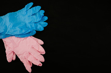 blue and pink gloves on a black background. Copy space.