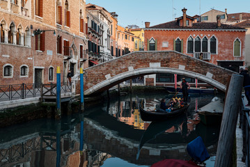 A gondola crossing a small bridge and heart of Venice