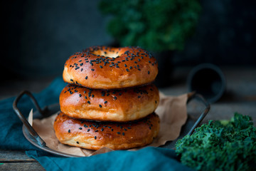 Homemade sesame bagels on an old wooden background