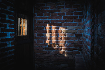 Light coming through a window on the brick wall in prison. Hight contrast dark shot