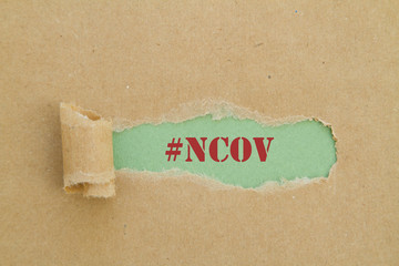 NCOV word written under torn paper.