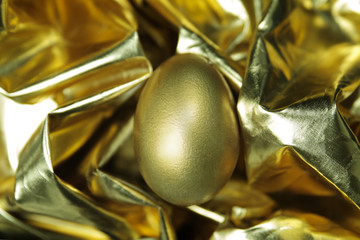 Golden egg lies on golden texture