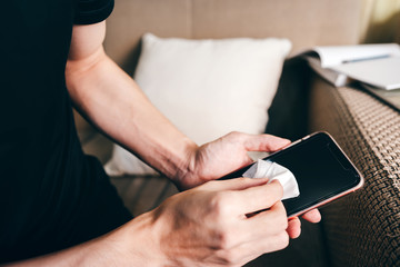 Adult hand use tissue with alcohol clean touch screen prevent virus.
