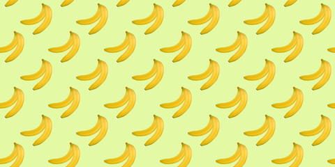 Seamless pattern of bananas isolated on green. Food background. Flat lay