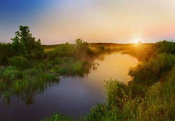 Dawn by the river in the summer spring season. Beautiful landscape of morning freshness.