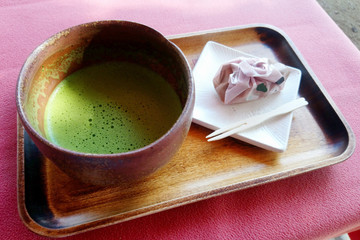 cup of green matcha tea and sweets
