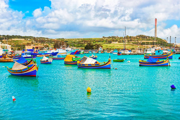 Fototapeta na wymiar Luzzu boats in Marsaxlokk Port at Mediterranean sea Malta