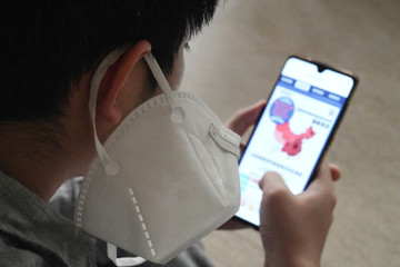 Wearing a mask of the boy see a mobile phone