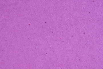 The surface of purple lilac cardboard. Rough natural paper texture with cellulose fibers. Bright saturated color. Background or wallpaper. Top view from above. Macro