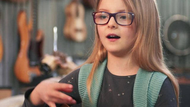 Dad teaching guitar and ukulele to his daughter.Little girl learning guitar at home.Close up.Ukulele class at home. Child learning guitar from her father