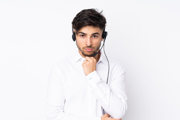 Telemarketer Arabian man working with a headset isolated on white background thinking an idea