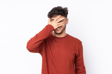 Arabian handsome man over isolated background covering eyes by hands and smiling